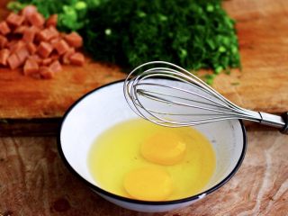 茴香火腿肠蛋炒饭,把鸡蛋打散后用手动打蛋器搅打均匀