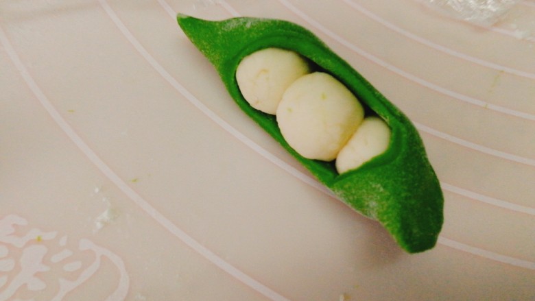 人见人爱的豌豆荚馒头,放好白色小圆团，把绿色面团包上结口捏紧
