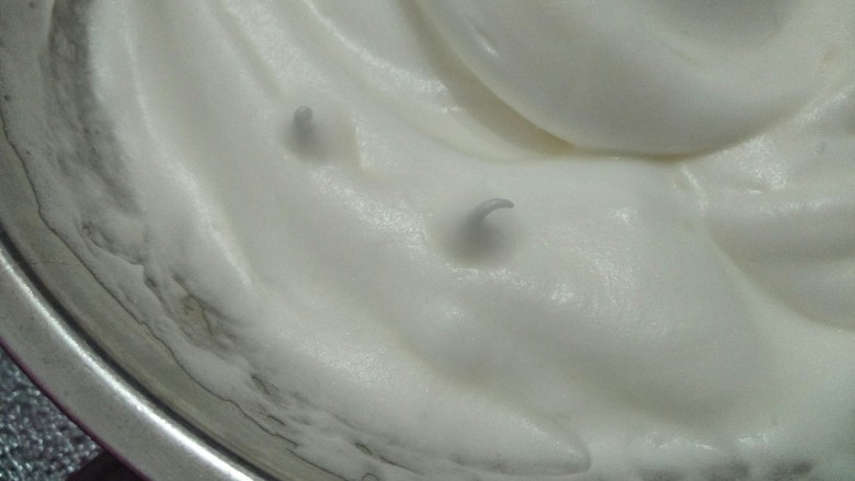坚果小蛋糕,将60克糖分三次加入蛋白中用电动搅拌器搅拌到提起打蛋头蛋白有弯钩的状态。