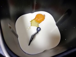 奶香吐司,面包机桶内倒入牛奶和淡奶油，打入一个鸡蛋。