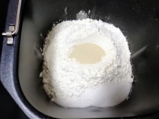 奶香吐司, 加入奶粉、低筋面粉和高筋面粉，糖和盐对角放，中间挖一个小坑，把干酵母埋起来。