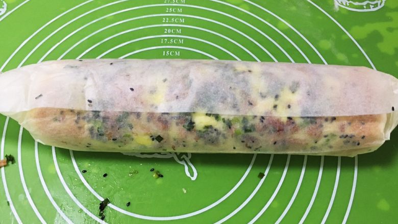 培根香葱面包卷,借助烤盘纸辅助卷起来，放冰箱冷冻20分钟定型。