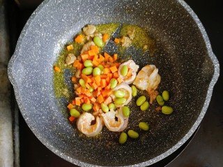 宝宝辅食—毛豆鹅肝虾仁蛋炒饭,倒入胡萝卜和毛豆，炒至胡萝卜断生