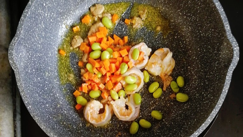 宝宝辅食—毛豆鹅肝虾仁蛋炒饭,倒入胡萝卜和毛豆，炒至胡萝卜断生