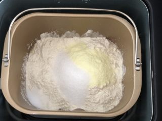 全麦豆沙软欧,放入面粉，糖，奶粉，盐放一个角落中，先慢速搅拌