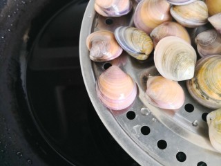 爆炒花蛤,锅中加入冷水。蒸隔放上洗净的花蛤