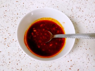 双色皮冻, 趁热浇在蒜泥和辣椒面上，根据自己的口味加入盐、鸡精、醋和生抽，调好料汁。