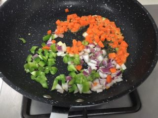 宝宝辅食10M➕：豆腐蔬菜条,锅里刷一层核桃油，先放入洋葱，然后加入胡萝卜和青椒炒至断生