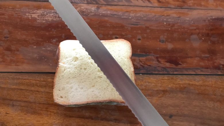 巨无霸口袋三明治,取一把锋利的锯齿刀，将三明治对半切开