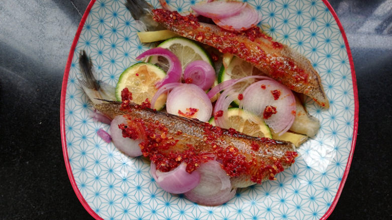 柠檬香辣烤冰鱼,油辣子均匀地抹在鱼身上。腌制15分钟。