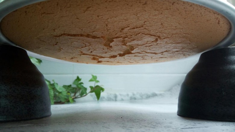 芝麻戚风蛋糕,将出炉的蛋糕立即倒扣在两个碗之间，凉透后才可以脱模。