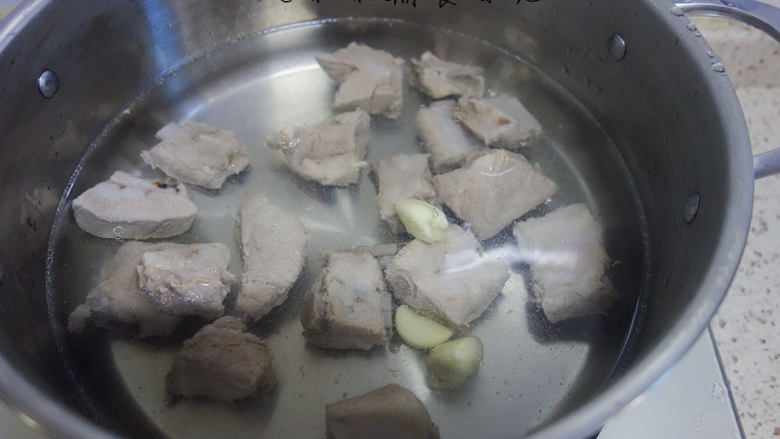 玉米排骨汤,准备一锅热水，加入猪肋排+3瓣大蒜+1勺料酒，水一定要没过所有材料