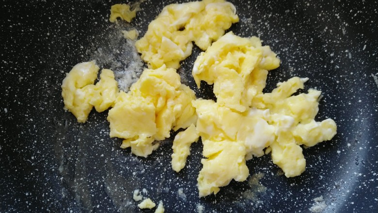 毛豆炒鸡蛋,鸡蛋翻炒凝固后，把鸡蛋倒入盘子。