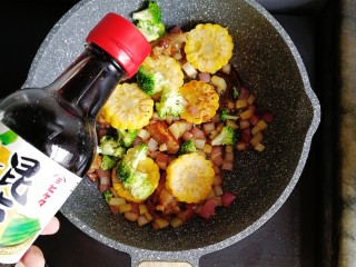 宝宝辅食—土豆玉米排骨焖饭,倒入适量的酱油翻炒均匀