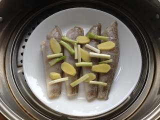清蒸南极冰鱼,冰鱼腌好后，将香葱段和姜片均匀摆放在冰鱼上，入蒸锅，上汽后蒸8分钟