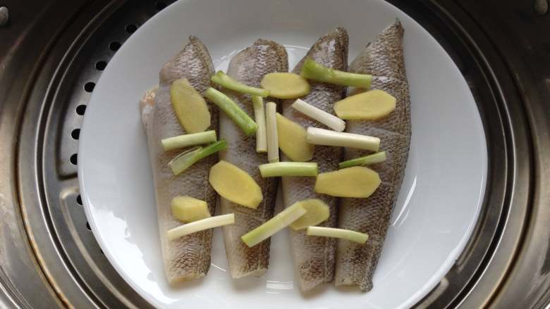 清蒸南极冰鱼,冰鱼腌好后，将香葱段和姜片均匀摆放在冰鱼上，入蒸锅，上汽后蒸8分钟