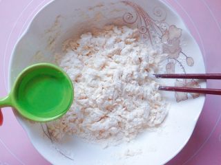 豆角饼,加入适量清水，少量多次的加，边加边用筷子搅拌成絮状。