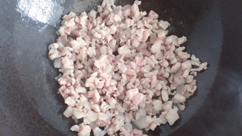 豆角饼,锅中倒入少许油烧热，下入五花肉丁炒至变色。