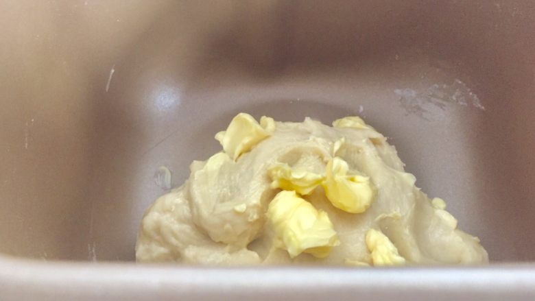 百搭迷你小餐包,启动一个和面程序。检测面团成团后倒入黄油。
