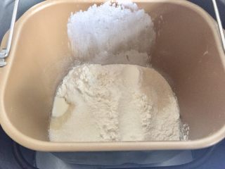 百搭迷你小餐包,然后除开黄油之外的其他原料一次性倒入。面包机桶盐和酵母对角放好。
