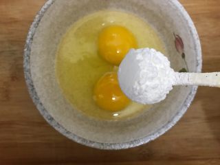 黑芝麻香肠鸡蛋卷,鸡蛋磕入碗内，加一勺淀粉