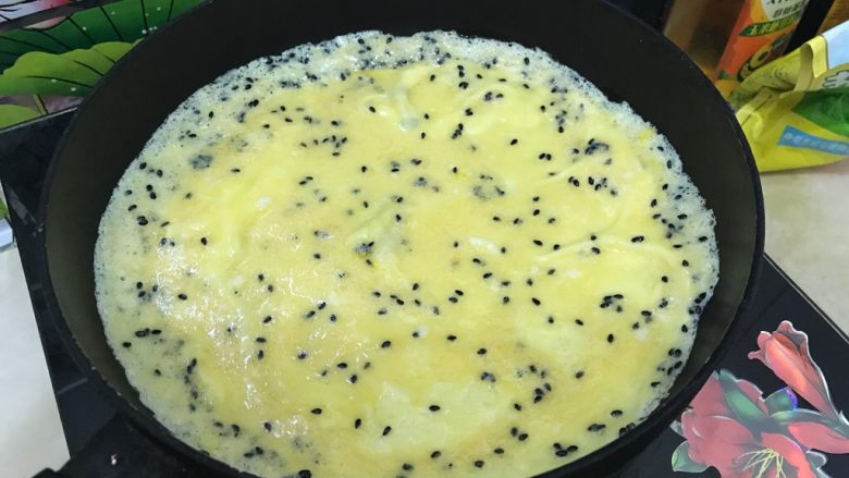 黑芝麻香肠鸡蛋卷,摊成圆形，小火慢煎