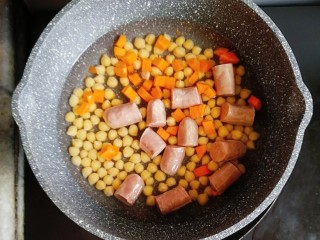 鹰嘴豆香肠咖喱意面,鹰嘴豆煮10分钟后，水倒掉，重新往锅内加400g水，煮开后，倒入香肠和胡萝卜，继续中火煮10分钟