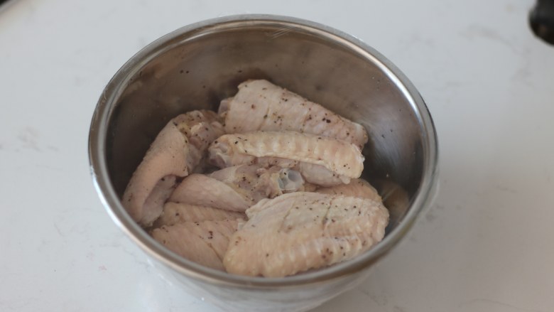 柠檬黑胡椒烤鸡翅,蒙上保鲜膜。放入冰箱腌制入味。冷藏半小时