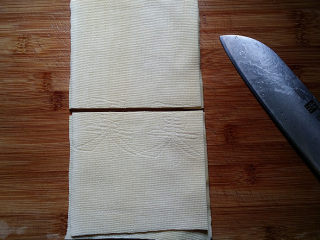 苜蓿香肠百叶卷,将买来的整张豆皮用水冲洗干净、一折为三叠成长条、中间切一刀成正方形