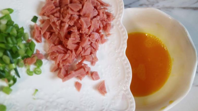 爱心营养早餐首选--厚蛋烧,往鸡蛋碗中加入切碎的<a style='color:red;display:inline-block;' href='/shicai/ 3232'>香葱</a>和火腿肠粒,搅拌均匀。