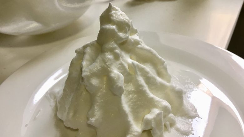午后甜点-漂浮雪山微波炉版,找一个能进微波炉的盘子，用勺子将打发好的蛋白霜做成一座雪山的形状