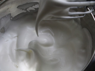 菠菜蛋糕卷,蛋白加入几滴柠檬汁，一次性加入白砂糖，打成如图，提起打蛋器能出现一个大弯钩的状态，倒扣打蛋盆蛋白霜不会掉出来。