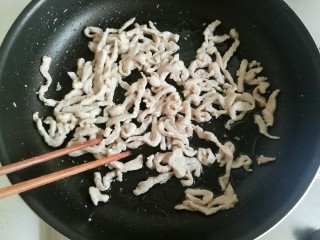 辣椒炒肉丝,用筷子把肉丝炒散。