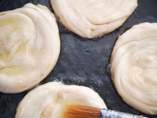 香酥椒盐饼,用油刷在面饼上刷上一层油后盖上盖子煎制