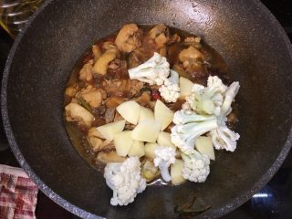 大盘鸡,开盖倒入花椰菜和土豆，继续盖上锅盖，中火煮至土豆熟烂