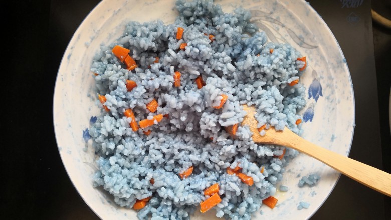 【蓝蝶芝士饭】,将胡萝卜丁拌入米饭中。