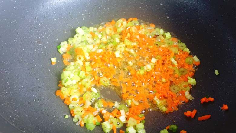 牛肉炒饭,锅里留少许油，放入西芹丁和胡萝卜丁炒至八九分熟。