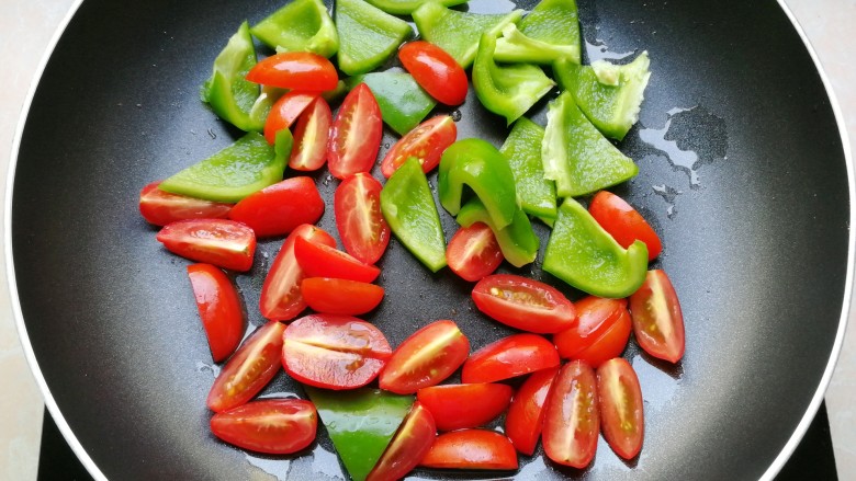 芝士彩蔬意面,放入小番茄和青椒，翻炒一下