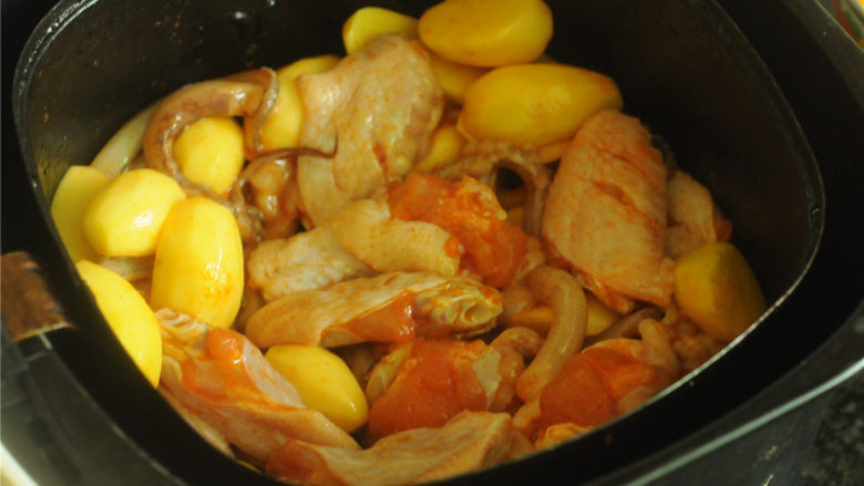 烤土豆鸡翅,将腌制好的食材倒入空气炸锅的炸篮里，平铺正确