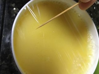 高汤蒸嫩蛋,盖上保鲜膜，用牙签在保鲜膜上扎几个孔。