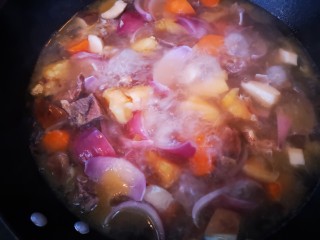 简单又美味~咖喱牛肉,将牛肉连汤一起倒入炒锅中后加入洋葱、胡萝卜和杏鲍菇一起煮