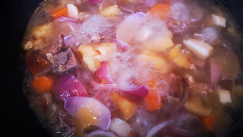 简单又美味~咖喱牛肉,将牛肉连汤一起倒入炒锅中后加入洋葱、胡萝卜和杏鲍菇一起煮