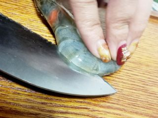 蓉粉丝开背虾,然后用刀把虾从背面偏开，用竹签把虾线一个一个的取出来，将大虾洗干净后放入盘中，再加入少许料酒腌制半小时。