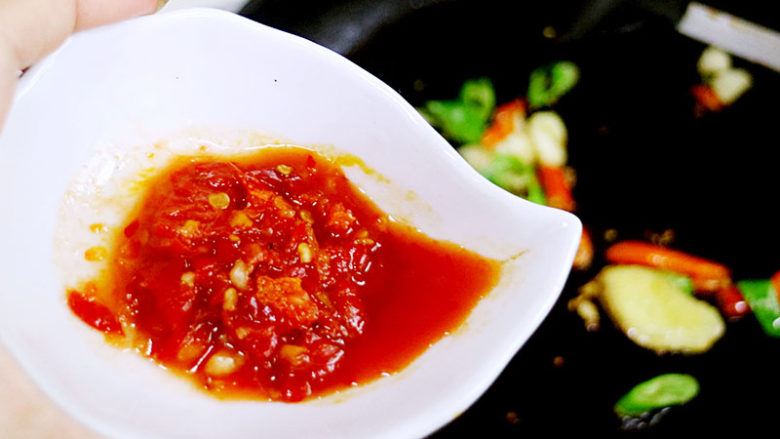 酸辣美味的酸汤肥牛,锅中加入适量热，爆香姜蒜末、杭椒和小米椒，接着放入辣椒酱炒香。