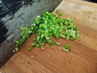 黄金鸡蛋面,趁着面糊静置的时间里，我们把食材处理一下。把洗净的青椒去籽，切成末备用。