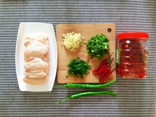 剁椒鸡翅,准备主料鸡中翅500g、剁椒酱25g、蒜末、葱花、香菜碎、小米椒5个、杭椒2个。