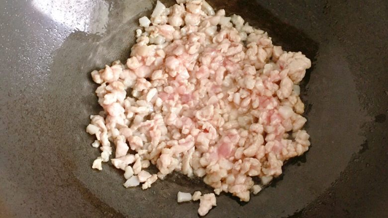 肉末炒豆角,锅中倒入适量油烧热，放入腌制好的肉末迅速炒散至肉变色；