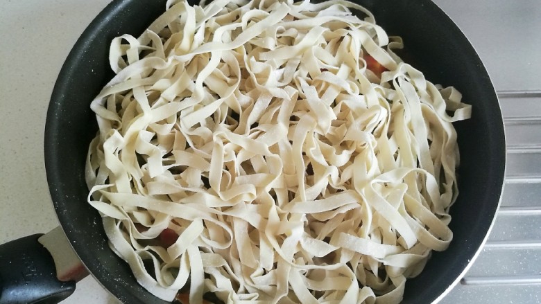 豆角番茄焖面,打开锅盖，将鲜面条均匀的铺在豆角上面。