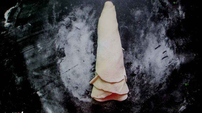 外焦里嫩、层次分明的手撕葱花饼,从划口处拽起一端一直往下卷，团成一个面坯