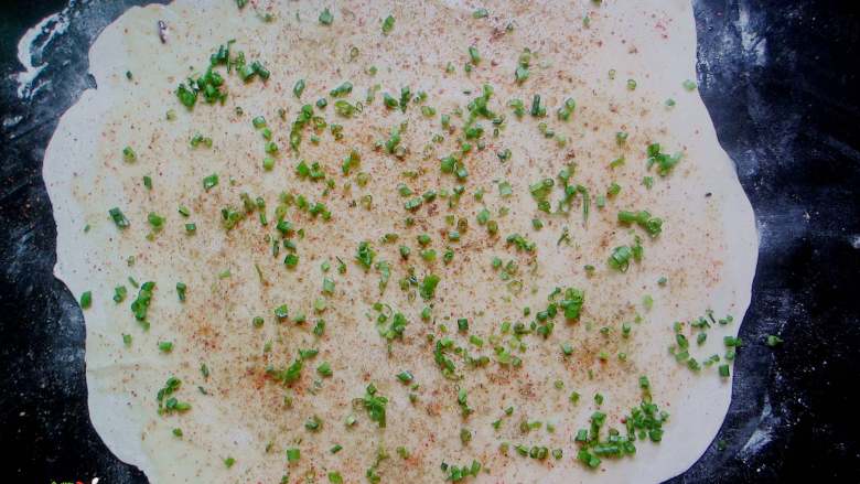 外焦里嫩、层次分明的手撕葱花饼,表面刷上一层猪油，撒上辣椒粉、五香粉、盐和葱花